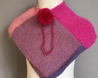 A Lovely Handmade Knitted Soft Baby Poncho in Different Pink and Lilac tones.