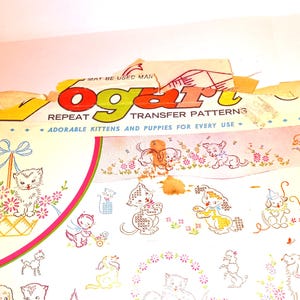 May include: Vintage Vogart transfer patterns featuring adorable kittens and puppies. The package has a yellow and white background with illustrations of various animals. The text "REPEAT TRANSFER PATTERNS" is visible.
