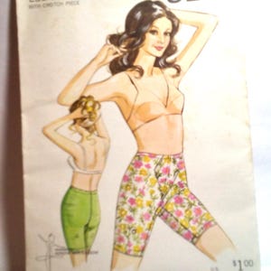 May include: Vintage sewing pattern for a ladies' girdle, pattern number 206, sizes 8-10-12-14. The pattern features a floral print and a white bra. The text "KWIK SEW" is printed in black at the top of the pattern.