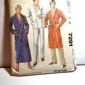 May include: A vintage McCall's sewing pattern for a men's robe. The pattern is for size large and features three different robe styles. The pattern is printed on a white background with a blue, red, and white polka dot border.