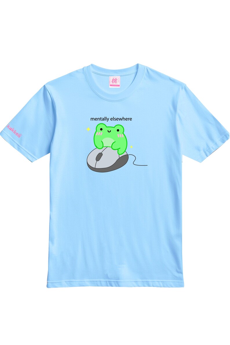 May include: Light blue t-shirt featuring a green cartoon frog sitting on a computer mouse. The text "mentally elsewhere" is above the frog. The word "kakkoii" is on the left sleeve.