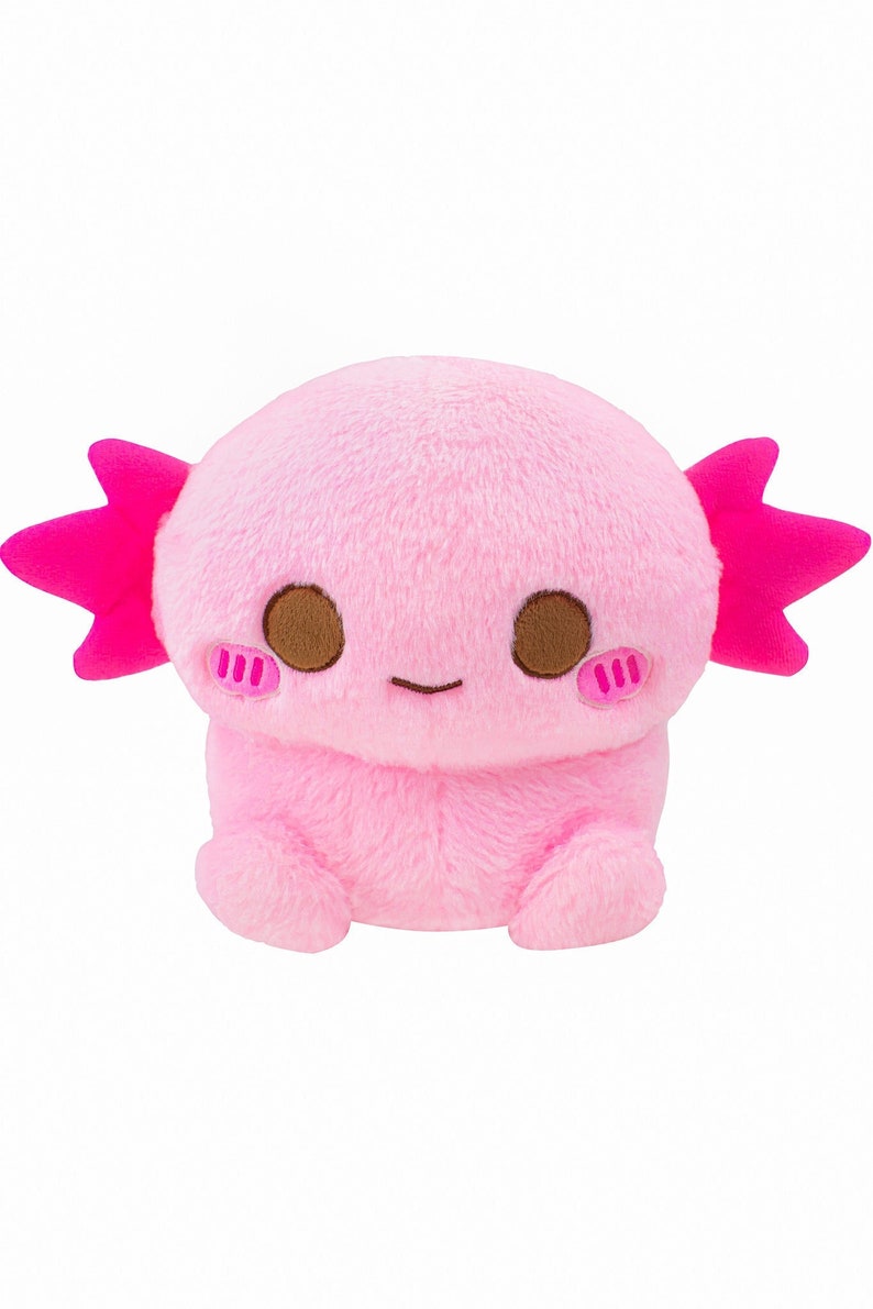 Może przedstawiać: R&oacute;żowa pluszowa zabawka axolotl z brązowymi oczami i r&oacute;żowymi falbankami. Axolotl siedzi na pupie z nogami schowanymi pod spodem.