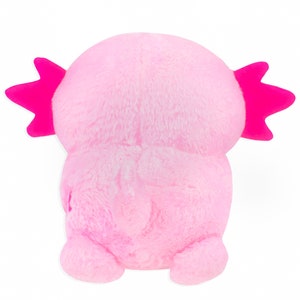 Może przedstawiać: R&oacute;żowa pluszowa zabawka axolotl z r&oacute;żowymi, pierzastymi skrzelami. Axolotl siedzi na białym tle.