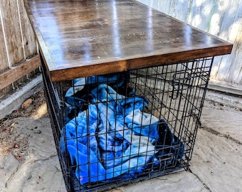 May include: A black metal dog crate with a wooden top. The crate is filled with a blue and white blanket.