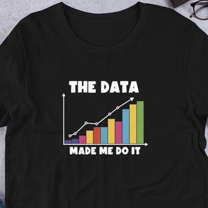 Puede incluir: Camiseta negra con un gráfico blanco de un gráfico de barras con el texto "The Data Made Me Do It".
