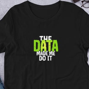 Könnte beinhalten: Schwarzes T-Shirt mit einer grün-weißen Grafik, auf der "The Data Made Me Do It." steht.