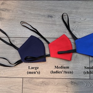 May include: Three face masks in different sizes, navy blue, red, and blue, with black elastic straps. The masks are labeled "Large (men's)", "Medium (ladies'/teen)", and "Small (child)".