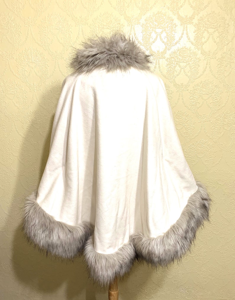 May include: White faux fur trim poncho with a gray faux fur collar and trim.
