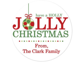 May include: A white circle sticker with red and green text that reads "have a HOLLY JOLLY CHRISTMAS" with a green and red ornament with white polka dots. The text "From, The Clark Family" is below the ornament.