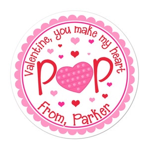 May include: A white circle sticker with a pink scalloped border. The sticker says "Valentine, you make my heart pop" in red letters with a pink heart-shaped pop-it toy in the center. The sticker also says "From, Parker" in red letters at the bottom.