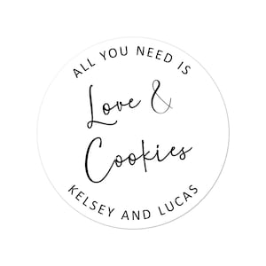 May include: White circle sticker with black text that reads "All you need is Love & Cookies Kelsey and Lucas".