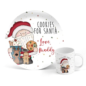May include: White ceramic plate with a cartoon Santa Claus holding cookies and milk. The plate has a red and green Christmas tree pattern and the text "Cookies for Santa Love, Maddy". A white ceramic mug with a cartoon Santa Claus holding cookies and milk. The mug has the text "Milk for Santa".