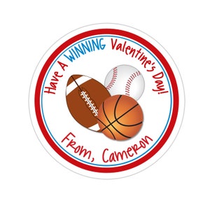 May include: Round Valentine's Day sticker with a red border and blue text. The sticker features a baseball, basketball, and football with the text "Have a Winning Valentine's Day! From, Cameron".