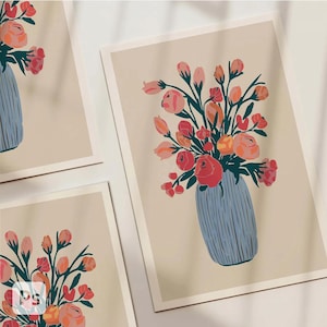 May include: Floral art prints featuring bouquets of pink, orange, and red flowers in blue vases. The artwork is set against a cream-colored background. The prints are displayed in a group, showcasing the floral arrangements.