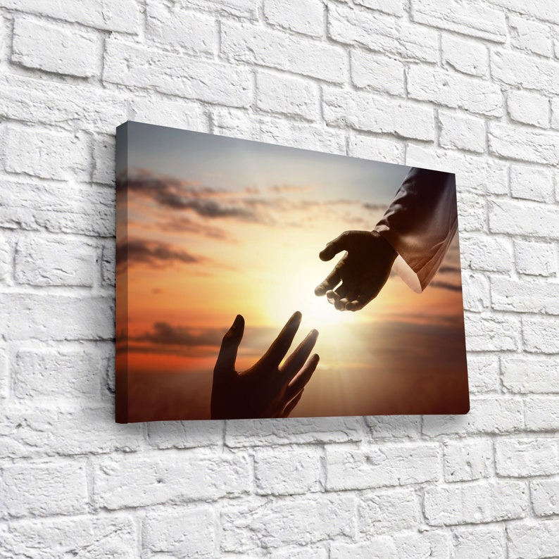 May include: A silhouette of two hands reaching towards each other against a sunset sky. The hand on the left is reaching up, while the hand on the right is reaching down. The sun is shining brightly in the background.