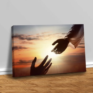 May include: A silhouette of two hands reaching towards each other against a sunset sky. The hand on the left is reaching up, while the hand on the right is reaching down. The sun is shining brightly in the background.
