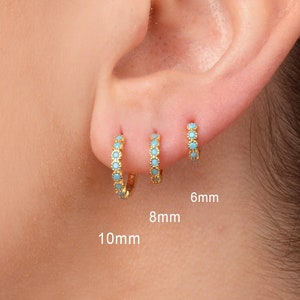 Peut inclure: Trois boucles d'oreilles créoles en or avec des pierres turquoise. Les boucles d'oreilles mesurent 6 mm, 8 mm et 10 mm de diamètre.