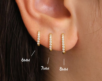 May include: Three gold hoop earrings with small diamonds set in the metal. The earrings are 6mm, 7mm, and 8mm in diameter.