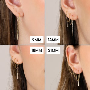 Puede incluir: Cuatro pares de pendientes de cadena de oro de diferentes longitudes con una peque&ntilde;a barra de oro que cuelga de la parte inferior. Los pendientes se muestran en la oreja de una modelo, con las longitudes etiquetadas como 9 mm, 14 mm, 18 mm y 21 mm.