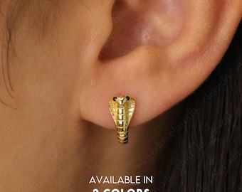 Puede incluir: Pendientes de aro en forma de serpiente de color dorado con detalles negros. Disponibles en dos colores.