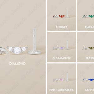 Op de afbeelding: Een set van 10 verschillende gekleurde edelsteen oorbellen. Elke oorbel heeft een zilveren post met een kleine cluster van drie edelstenen. De edelstenen zijn verkrijgbaar in diamant, granaat, smaragd, alexandriet, peridoot, roze toermalijn en saffier.