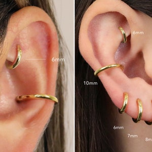 May include: Close-up of a person's ear with multiple gold hoop earrings in different sizes. The earrings are 6mm, 7mm, 8mm, 10mm, and 6mm in diameter.