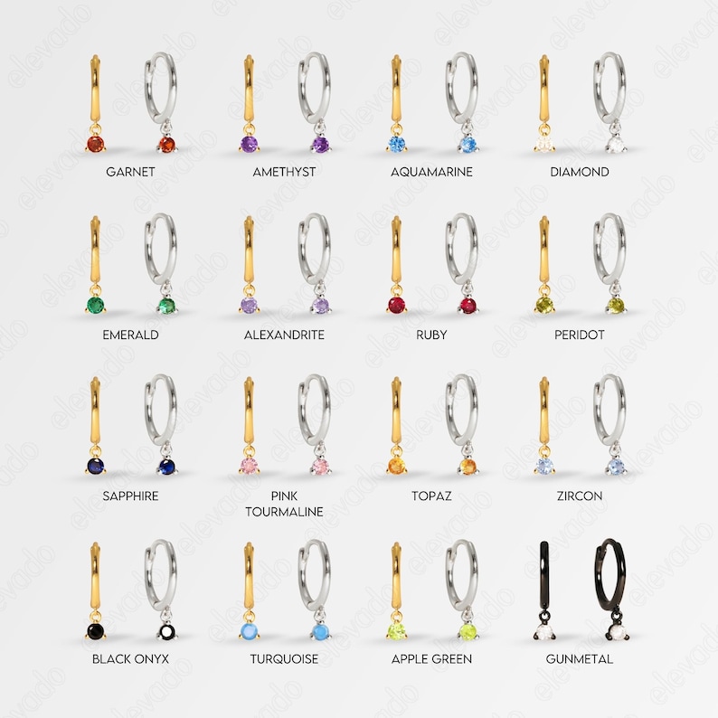 K&ouml;nnte beinhalten: Ein Set mit 14 Paaren silberner Creolen mit einem baumelnden Edelstein-Anh&auml;nger. Die Edelsteine sind in verschiedenen Farben, darunter Rot, Gr&uuml;n, Blau, Lila, Pink, Gelb und Schwarz.