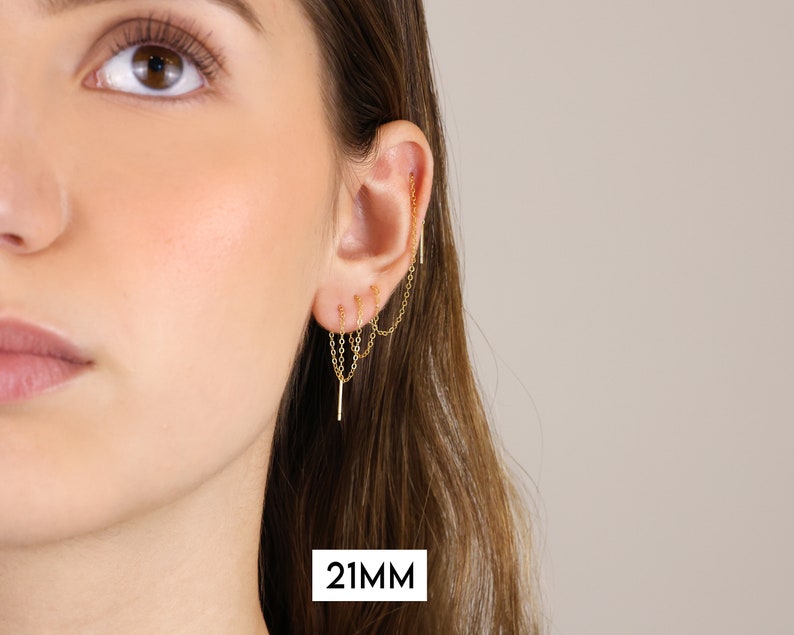 Puede incluir: Pendiente de oreja dorado con m&uacute;ltiples cadenas que cuelgan. La cadena mide 21 mm de largo.
