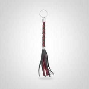 May include: A black and red leather keychain with a braided design and a silver key ring.