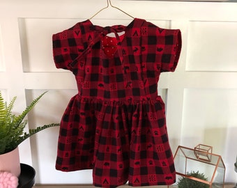 Relaxed fit girl/toddler back to pre-school dress.  Warm Red/blk buffalo print flannel.  Short V in back with matching ties.