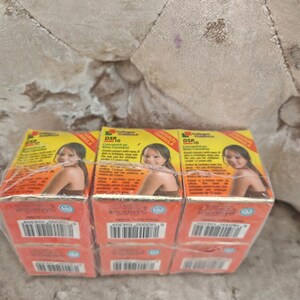 May include: A set of six rectangular boxes of DSP 10 Collagen Formula skin cream wrapped in clear plastic. Each box features a yellow top section with a photograph of a person, red bottom section, and printed text including the brand name Gandour.