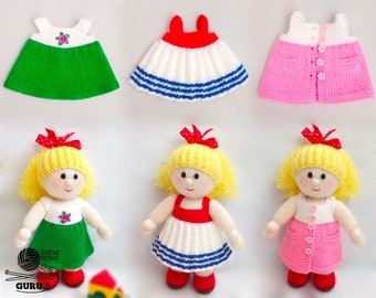 Può includere: Tre bambole di lana con capelli gialli e fiocchi rossi, che indossano abiti di diversi colori. Le bambole indossano abiti verdi, rosa e bianchi con strisce blu. Le bambole sono in piedi su una superficie bianca.