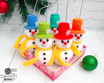 Può includere: Sei addobbi di pupazzo di neve a maglia con cappelli e sciarpe di diversi colori. Gli addobbi sono in una scatola rosa e bianca con le parole "Eat a cookie" stampate sul lato.