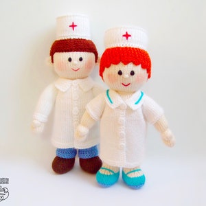 May include: Two knitted dolls dressed as nurses. The dolls are wearing white uniforms with red crosses on their hats. One doll has brown hair and the other has red hair.
