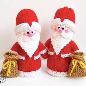May include: Two knitted Santa Claus figures with white beards, red suits, and white trim. Each Santa is holding a brown sack with a yellow string.