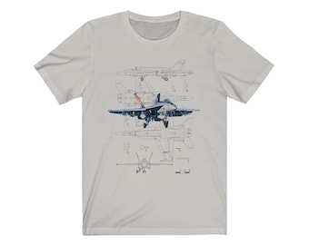 May include: A grey t-shirt with a blue and white illustration of a fighter jet. The illustration shows the jet in different positions, including a side view, a top view, and a front view. The jet is labeled with letters A through G.