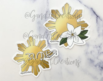 May include: Two gold sun stickers with eight points each. The top sticker has a white flower with green leaves. The bottom sticker has the text "30+ years" in white. Both stickers have the text "@GandiArt.Creations" in black.