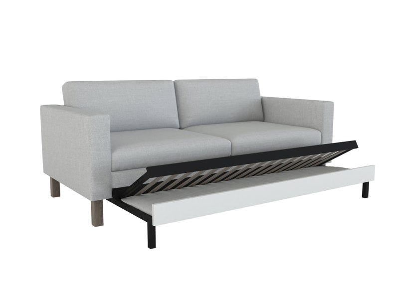 May include: A light grey fabric sofa with a pull-out bed. The bed is partially extended, revealing a black metal frame and a white mattress.