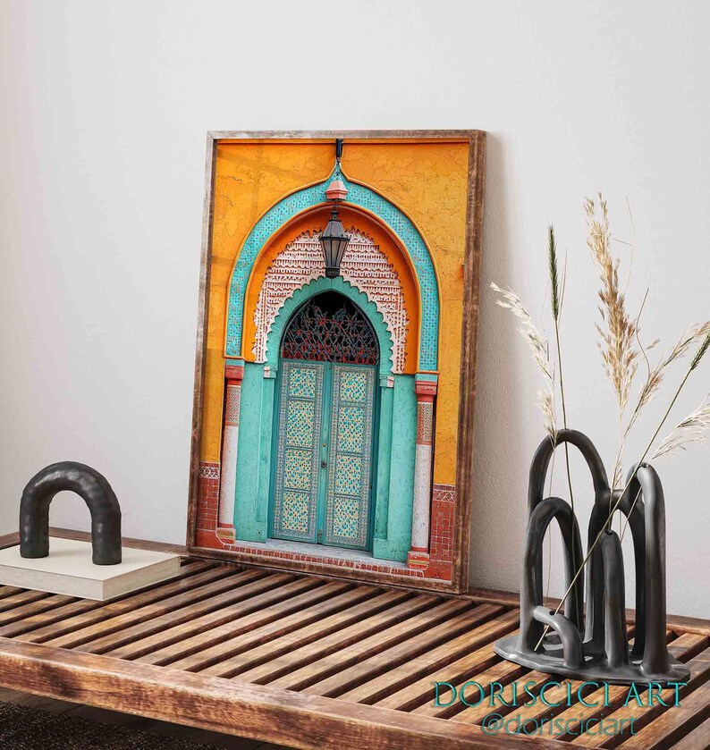 May include: A framed print of a colorful, ornate doorway with a teal archway and a wooden door with intricate carvings. The door is set against a yellow background with geometric patterns.