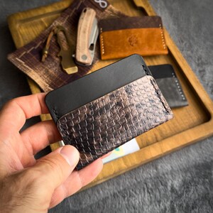 Cartera minimalista de piel negra y con relieve de pitón.