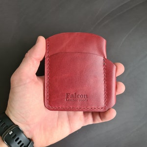 May include: A burgundy leather wallet with the text "Falcon Leather Goods" embossed on the front.