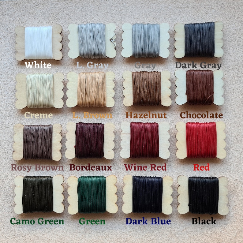 Puede incluir: Una colecci&oacute;n de 14 carretes de hilo encerado en varios colores, incluyendo blanco, gris, marr&oacute;n, rojo, verde y azul. Cada carrete est&aacute; etiquetado con el nombre de su color.