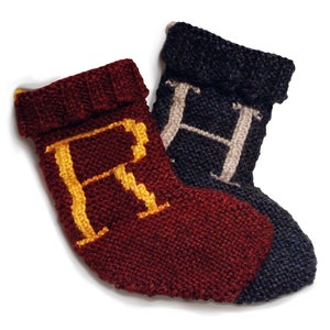 Peut inclure: Deux chaussettes de Noël en tricot, une rouge avec un "R" doré et une bleu marine avec un "H" blanc.