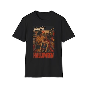 May include: A black short-sleeve t-shirt featuring a vintage-style graphic of a person and a child in a Kmart store aisle. The graphic includes the text simply Kmart and HALLOWEEN, with the child holding a box labeled SUPERHERO costume.