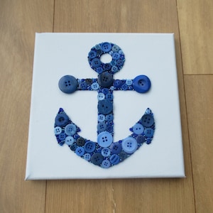 Op de afbeelding: Een blauwe anker gemaakt van knopen op een witte canvas achtergrond.