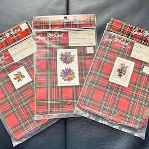 May include: Three needlepoint kits with red and green plaid packaging. Each kit features a different floral design with a white background. The kits are labeled "Petit Point Kit" and "Trousseau de Petit Point".