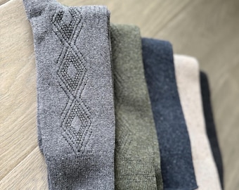 May include: A stack of five pairs of socks in various colors, including gray, green, black, and beige. The socks have a diamond pattern and are made of a soft, knitted fabric.