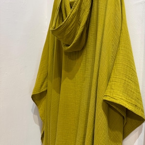 Pu&ograve; includere: Un poncho giallo senape con cappuccio in tessuto morbido e vaporoso. Il poncho ha una vestibilit&agrave; rilassata ed &egrave; perfetto per essere indossato a strati.