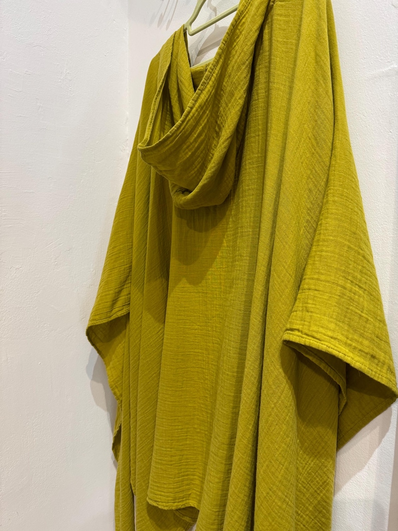 Pu&ograve; includere: Un poncho giallo senape con cappuccio in tessuto morbido e vaporoso. Il poncho ha una vestibilit&agrave; rilassata ed &egrave; perfetto per essere indossato a strati.