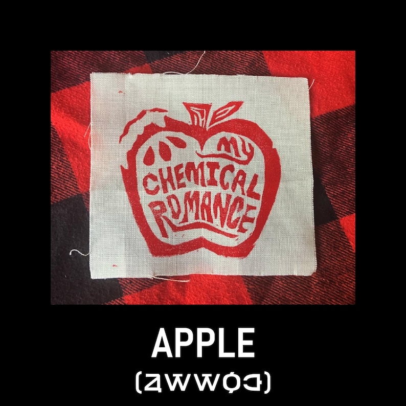 May include: A square, off-white patch with a red apple design and the words "My Chemical Romance". The patch is on a red and black plaid background, with the word "APPLE" and a symbol below.